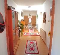 Interior of a family house with wooden furniture, a hallway, and rugs on the floor.