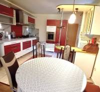 A kitchen unit with a dining table and chairs in a family house.