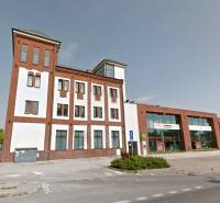A building with commercial spaces on Bratislavská Street in Šamorín, with glass and brick facades.