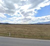 A vast field under a cloudy sky in Sučany, ideal for commercial purposes.