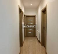 Hallway with light walls and wooden doors in a family house.