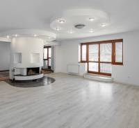 A spacious living room in a 5 or more bedroom apartment with a fireplace and staircase.