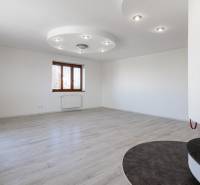 A spacious room with white walls and wooden flooring in a 5 or more room apartment.