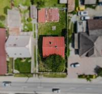 Aerial view of a family house in Pruské with a red roof and a garden.