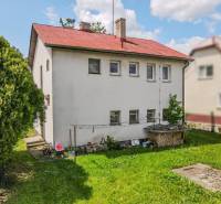 A family house in Pruské with a garden, white facade, and red roof.