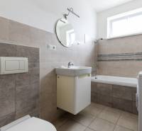 Bathroom in a 2-room apartment with a shower, sink, and washing machine.
