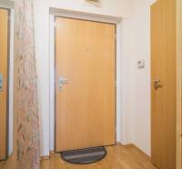 A balcony of a 3-room apartment with a view of a quiet street and greenery in Poprad.