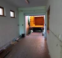 Production premises with a garage door and a parked truck for loading goods.