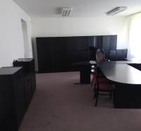 Office with black furniture and a large table in the production area.