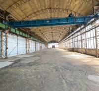 Interior of a warehouse and hall with an overhead crane and a high arched ceiling.