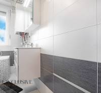 A bathroom in a 2-room apartment with a combination of white and gray tiles.