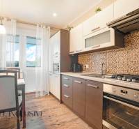 A kitchen in a 2-room apartment with a dining table and a cooktop.
