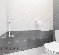 A bathroom in a 2-room apartment with tiles in white and gray shades.