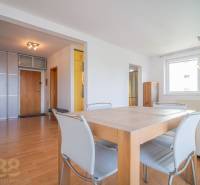 Dining table with chairs in a bright living room of a three-room apartment.