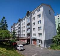 Apartment building on Levočská Street in Poprad with trees and parked cars.