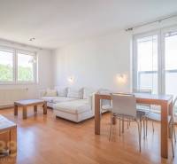 Living room in a three-room apartment with a corner sofa and wooden furniture.