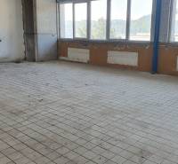 Empty room with tiles, large windows, and a view of the industrial area.
