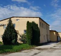 Warehouses and halls on Kpt. Nálepku Street in Ilava, a building surrounded by trees and grass.