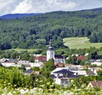 A picturesque panorama of Lutila with agricultural and forest lands and a church surrounded by green forests.