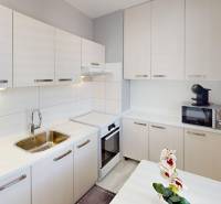 Kitchen unit with white cabinets in a 2-room apartment, complemented by a microwave oven.