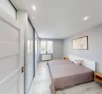 A bright bedroom with a bed and wooden furniture in a 2-room apartment.