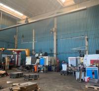 Production equipment in indoor warehouse and hall spaces with industrial machines.