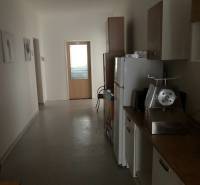 A small kitchenette in offices, with a refrigerator and a meal preparation appliance.
