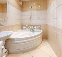 A bathroom with a corner bathtub and a sink in a 3-room apartment.