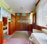 Interior of a family house with wooden paneling, decorations, and floral arrangements.
