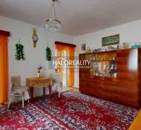 Family house with a living room, wooden display cabinet, curtains, and decorative elements.
