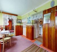Interior of a family house with wooden paneling and lace curtains.