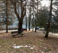 A park with a bench and trees in the city of Banská Bystrica, an ideal place for a 2-room apartment.