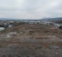 A construction site in the commercial area of Dubnica nad Váhom with industrial buildings in the background.