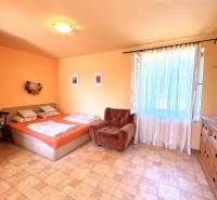 A bright room in a cabin with a double bed and a wardrobe.