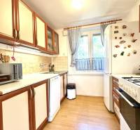 A kitchen in a cottage with light wooden furniture and appliances.