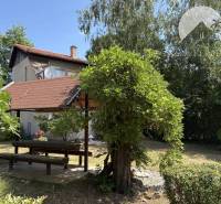 A cottage in Radvaň nad Dunajom with a garden seating area and surroundings full of greenery.