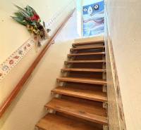 A wooden staircase in a cottage with decorative details on the walls.