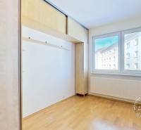 A bright room with a wooden floor and a built-in wardrobe in a 4-room apartment.
