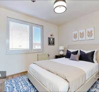 A bedroom in a 4-room apartment with a large bed, nightstands, and decorative paintings.