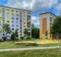 Apartment buildings near the playground on Okružná Street in Stará Ľubovňa with a children's playground and greenery.