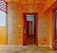 Interior of a 4-room apartment with wooden and brick details and open doors.