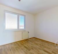 An empty room in a 4-room apartment with wooden flooring and a radiator.