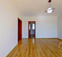 An empty room with a wooden floor and a ceiling light in a 4-room apartment.