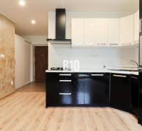 Kitchen in a 3-room apartment, black cabinets, built-in appliances, wooden floor.
