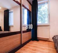 Bedroom in a 3-room apartment with a large wardrobe, window, and bed.