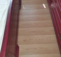 The floor in a 2-room apartment with red wooden furniture and a bed.