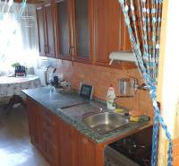A kitchen with a wooden cabinet and appliances in a 2-room apartment.