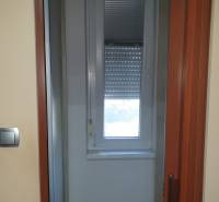 Sliding door and window with a blind in a 2-room apartment.
