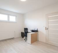 A room in a 3-room apartment with a desk, chair, and window.