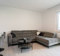 Living room in a 3-room apartment with a comfortable gray sofa and a balcony.